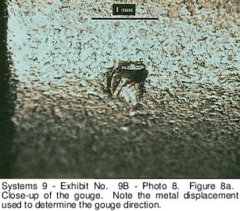 Systems 9 - Exhibit No. 9B - Photo 8. Figure 8a. Close-up of the gouge. Note the metal displacement used to determine the gouge direction. 