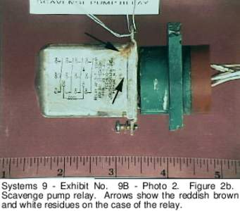 Systems 9 - Exhibit No. 9B - Photo 2. Figure 2b. Scavenge pump relay. Arrows show the reddish brown and white residues on the case of the relay. 