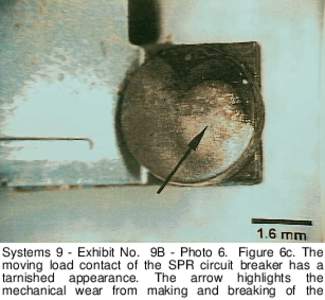 Systems 9 - Exhibit No. 9B - Photo 6. Figure 6c. The moving load contact of the SPR circuit breaker has a tarnished appearance. The arrow highlights the mechanical wear from making and breaking of the  