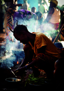 A displaced woman prepares food in a makeshift kitchen in the grounds of the Roman Catholic church in Bossangoa,